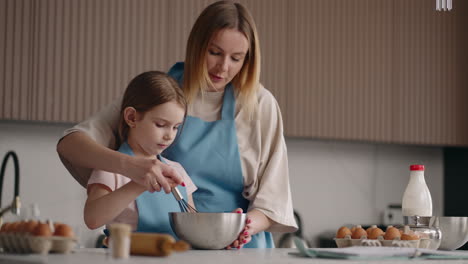 mother-is-teaching-her-little-daughter-to-cook-helping-to-whip-cream-for-cake-mom-and-child-girl